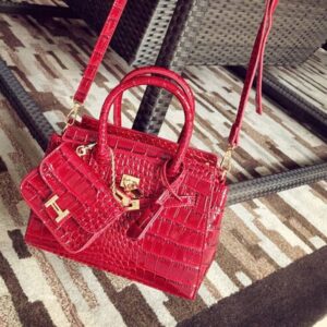 crocodile patterned red patent sleeve bag